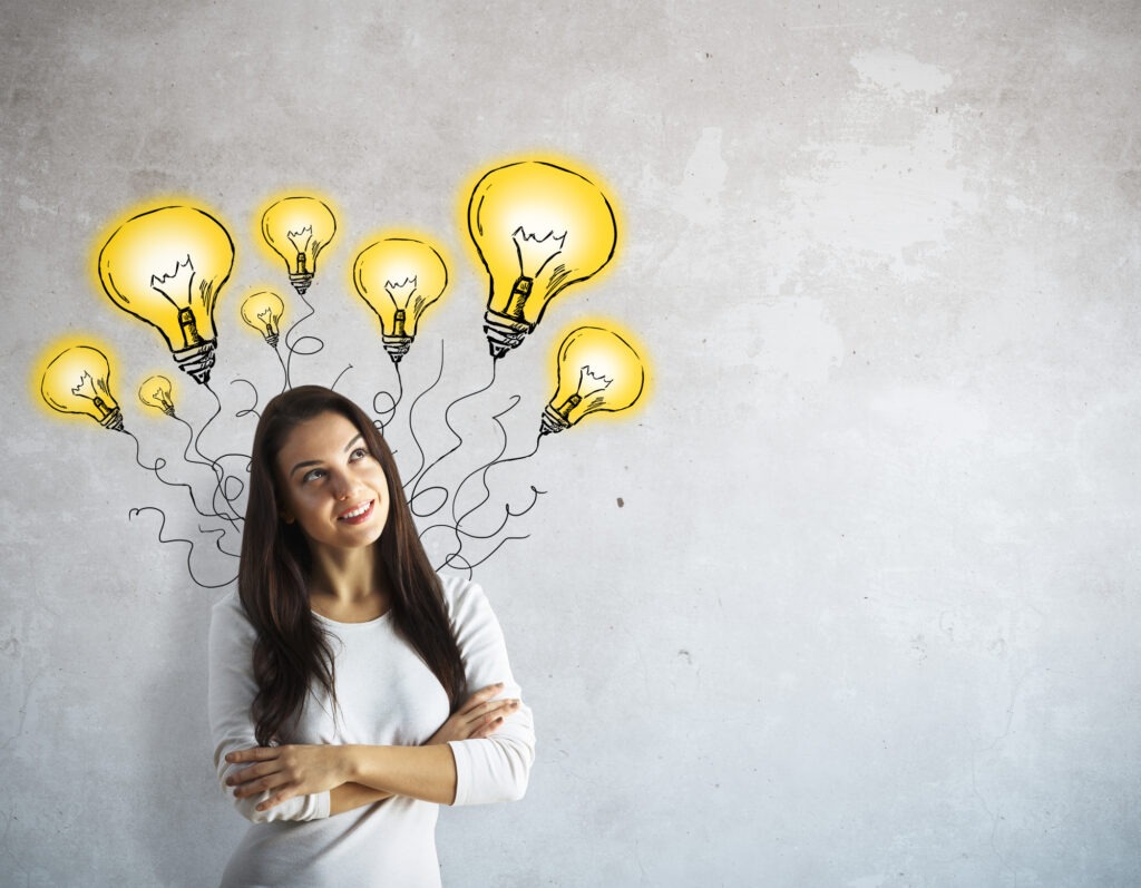 Beautiful european woman thinking on concrete background with abstract drawn lamps. Idea concept.
